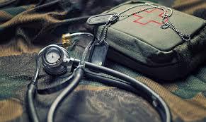 A stethoscope and first aid kit on the ground.